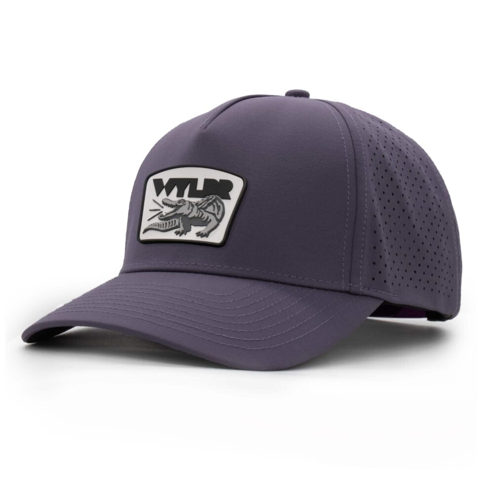three-quarter view of a 5 panel, water resistant, floatable hat with a PVC patch. the patch is a gator catching a golf ball in its mouth and features the brand name, Wyldr. the hat is dark purple
