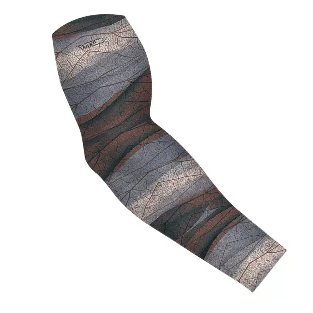 an image of an arm sleeve in an abstract pattern. lines are used to create the illusion the veins that run through leaves. the colors behind it are designed to mimic ocean waves. this is in the lake/cedar color variant