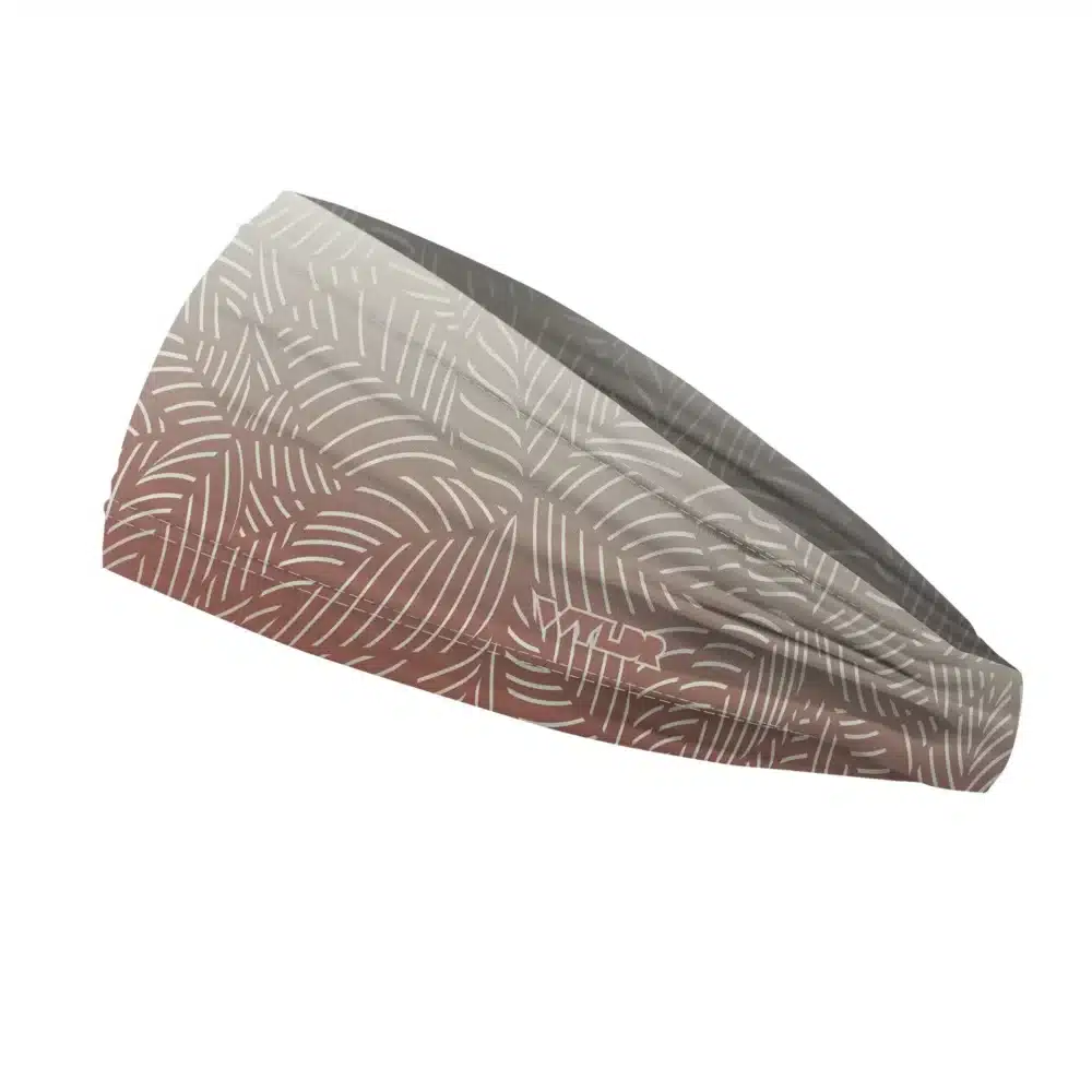 Side view of a headband that is 3 inches at the front and 1 inch in the back to show that it is tapered. This design is an abstract pattern. lines are used to create the illusion of leaves on a gradient color background. this is in the dune/putty color variant
