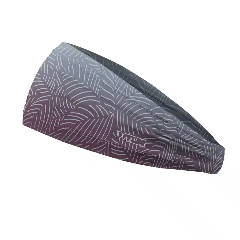 Side view of a headband that is 3 inches at the front and 1 inch in the back to show that it is tapered. This design is an abstract pattern. lines are used to create the illusion of leaves on a gradient color background. this is in the vine/lake color variant
