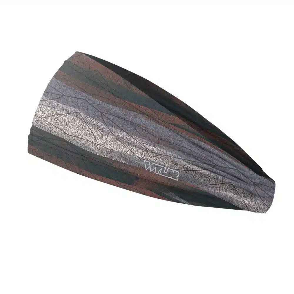 Side view of a headband that is 3 inches at the front and 1 inch in the back to show that it is tapered. The colors behind the print mimic waves. The design features lines and breaks to recreate the look of a leaf print. This image showcases cool reds, blues and grays.