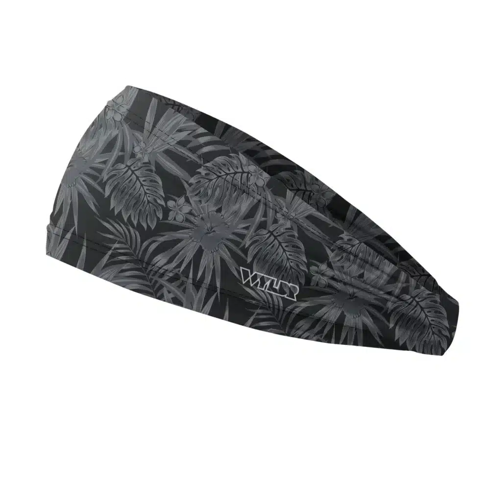 Side view of a headband that is 3 inches at the front and 1 inch in the back to show that it is tapered. The design is an abstract pattern. lines are used to create the illusion of tropical flowers and leaves on a solid color background. this is in the coal/smoke color variant