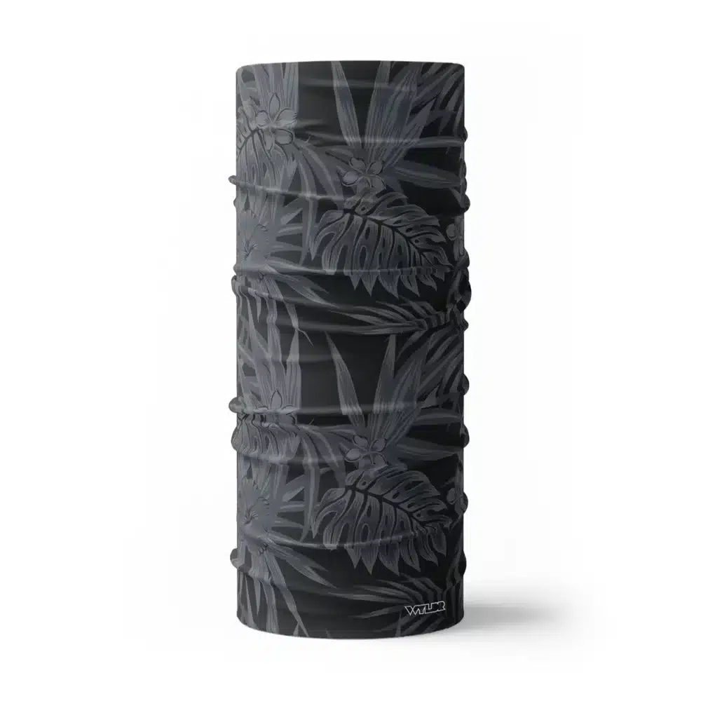 an image of a full size neck gaiter in an abstract pattern. lines are used to create the illusion of tropical flowers and leaves on a solid color background. this is in the coal/smoke color variant