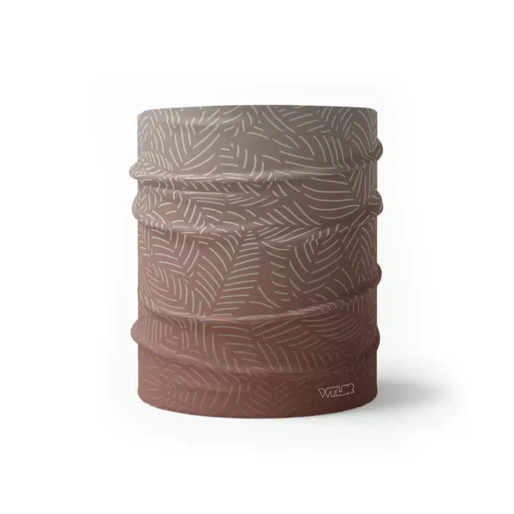 image of a wide sports headband with a crisp leaf pattern overlaid on a gradient background. The colors used in the gradiant are dune, putty and cedar.