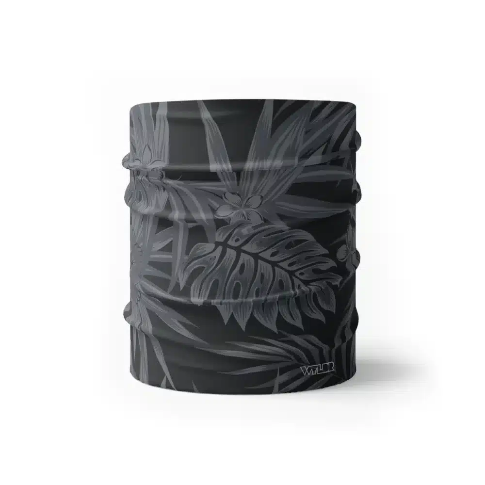 an image of a half size neck gaiter in an abstract pattern. lines are used to create the illusion of tropical flowers and leaves on a solid color background. this is in the coal/smoke color variant