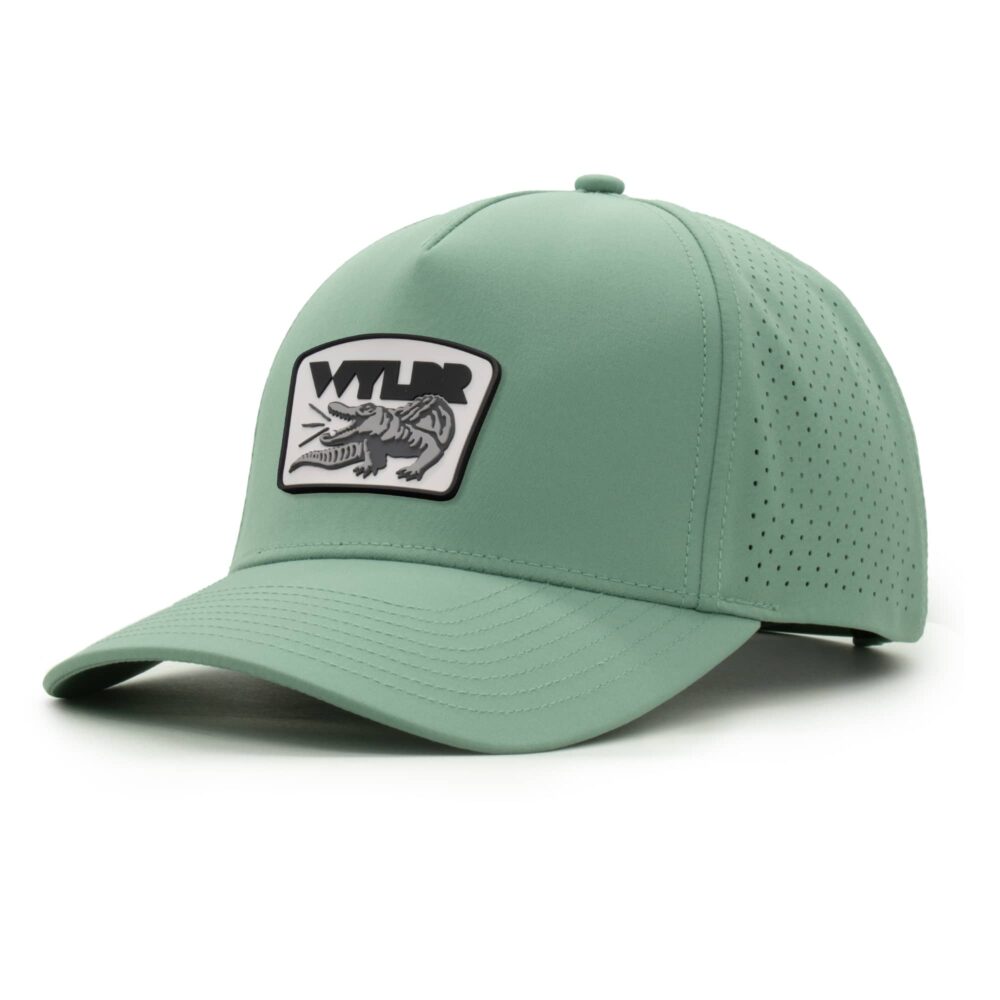 three-quarter view of a 5 panel, water resistant, floatable hat with a PVC patch. the patch is a gator catching a golf ball in its mouth and features the brand name, Wyldr. the hat is light green