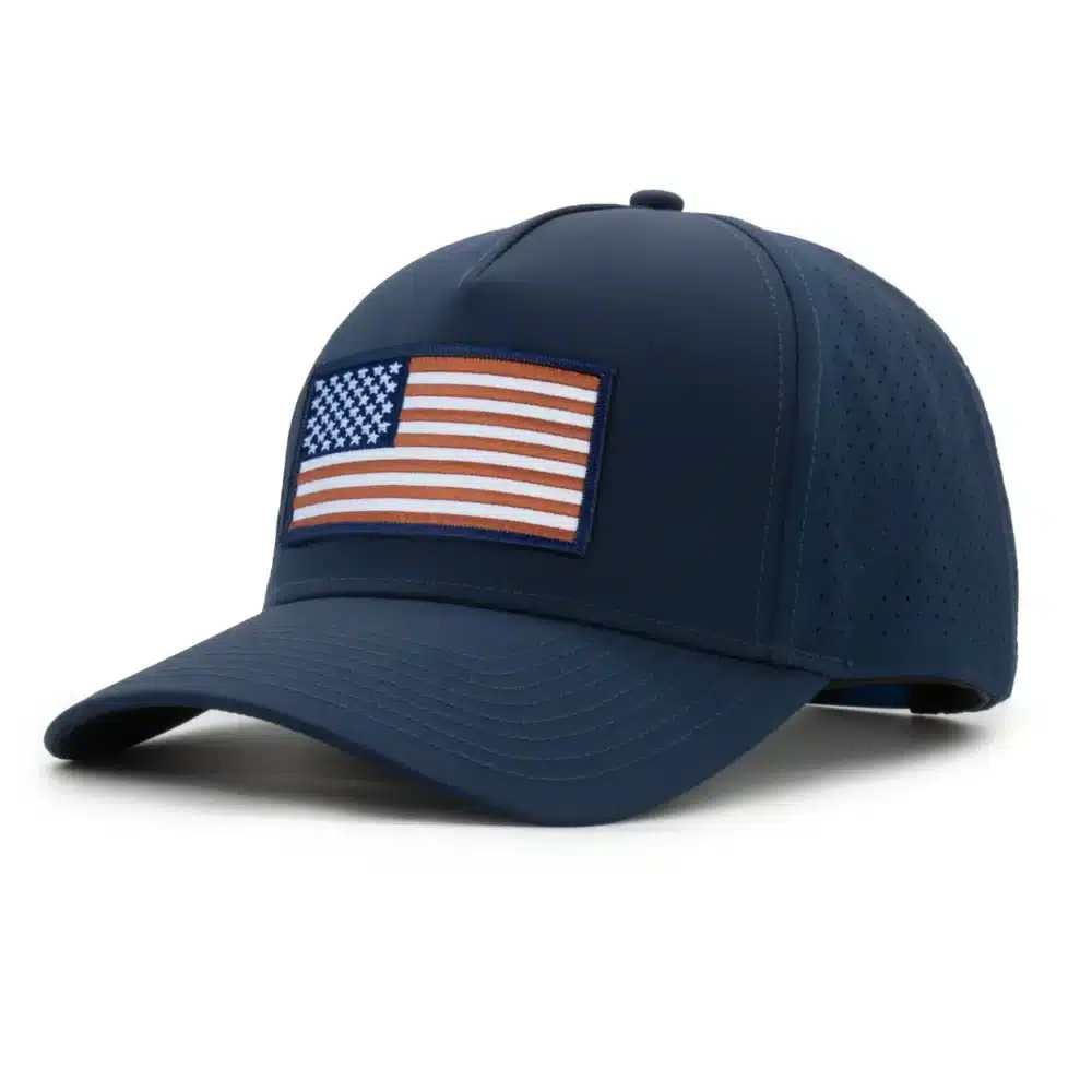 three-quarter view of a 5 panel, water resistant, floatable hat with an embroidered american flag patch. the hat is a dark blue color.
