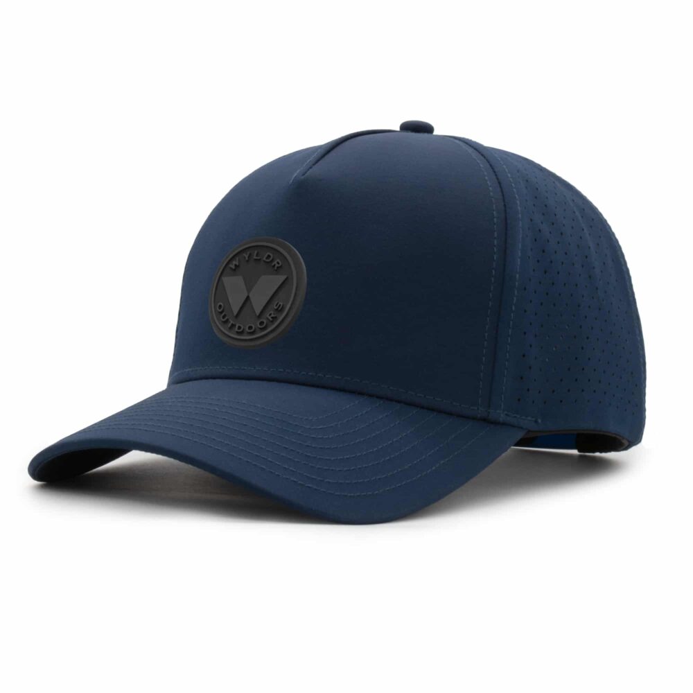 three-quarter view of a 5 panel, water resistant, floatable hat with a PVC patch. the patch is a round medallion featuring the letter W and the text Wyldr Outdoors. the hat is dark blue