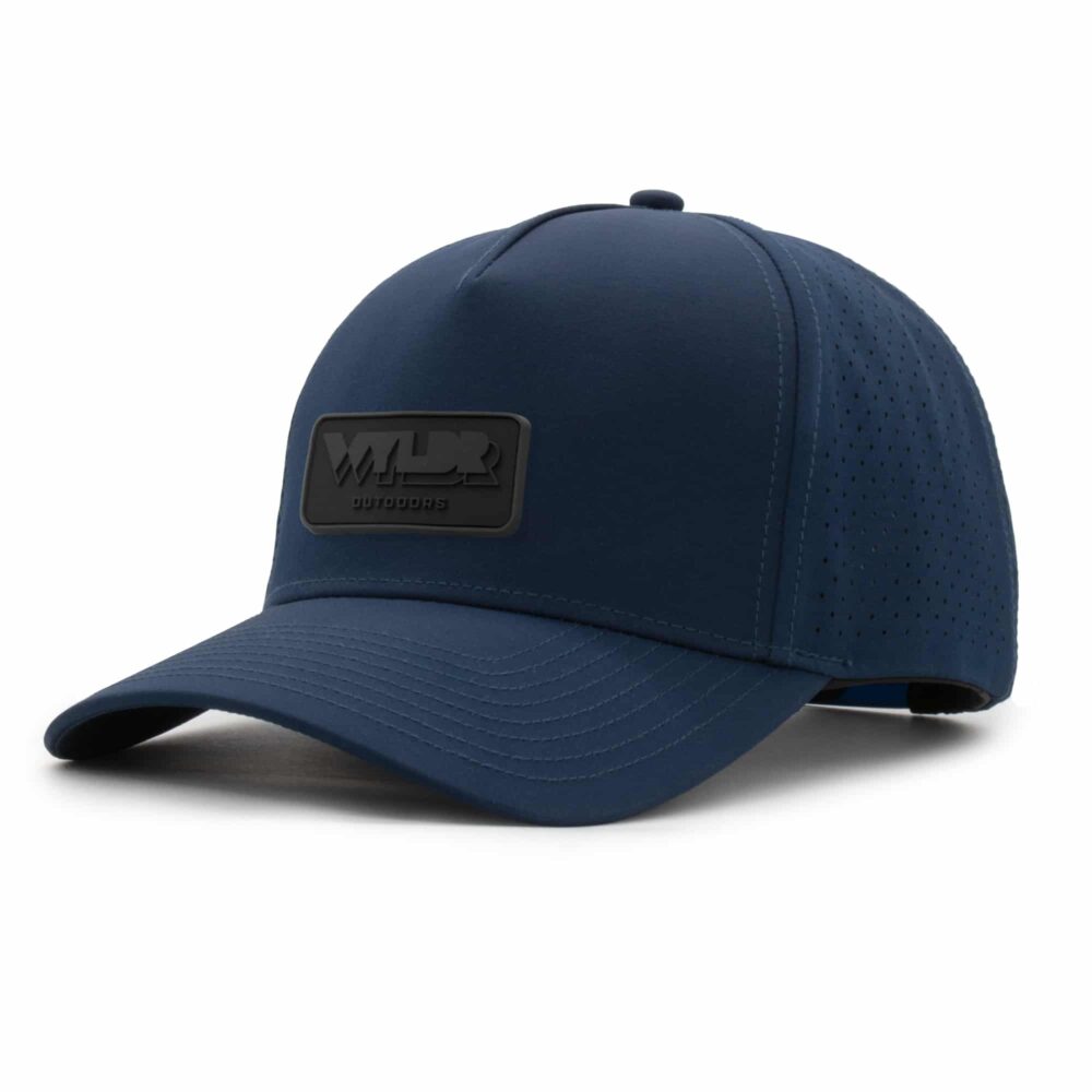 three-quarter view of a 5 panel, water resistant, floatable hat with a PVC patch. the patch is the brand name Wyldr contained in a rounded rectangle. the hat is dark blue.