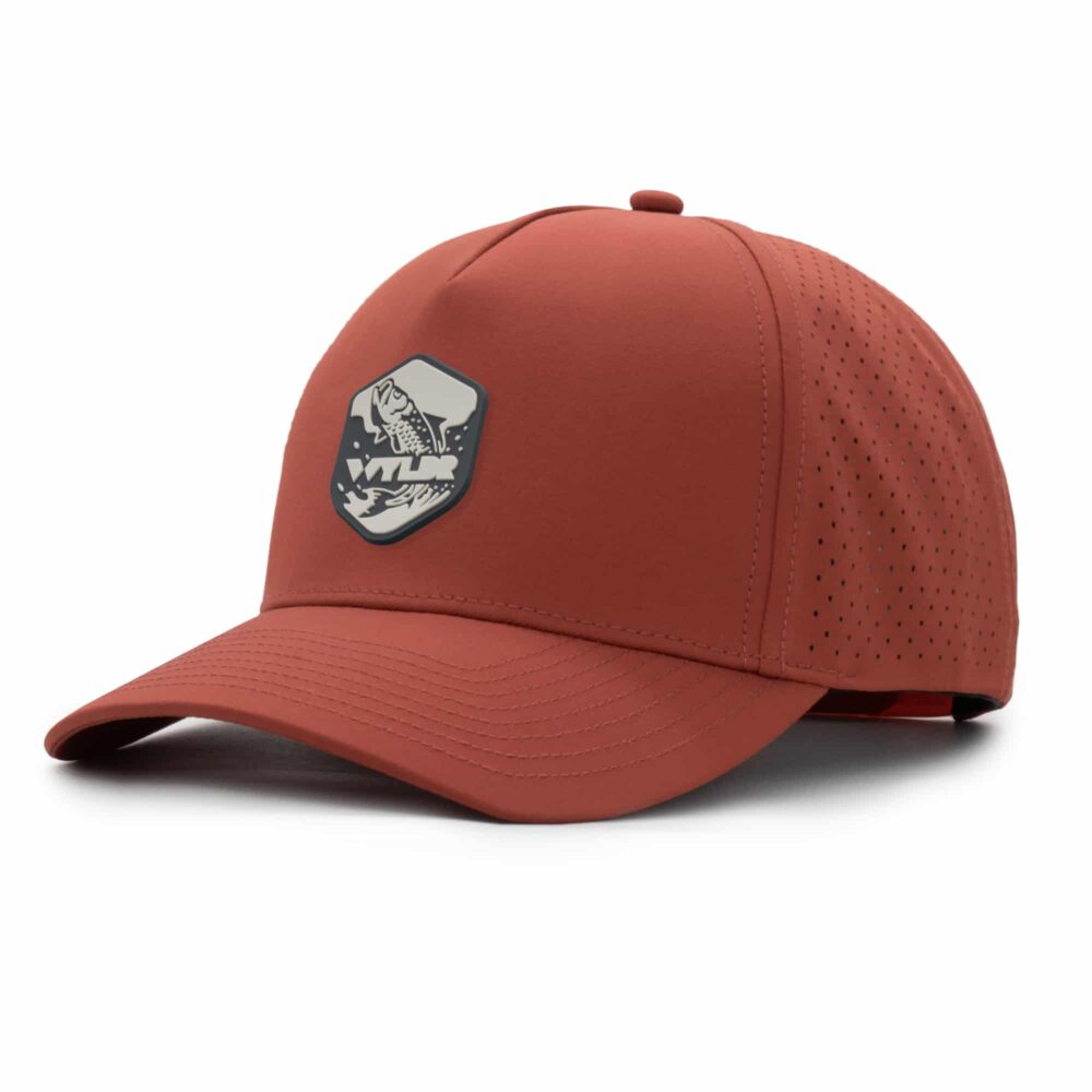 three-quarter view of a 5 panel, water resistant, floatable hat with a PVC patch. the patch is of a tarpon splashing out of the water and has the brand name Wyldr over it. the hat is a rusty orange color