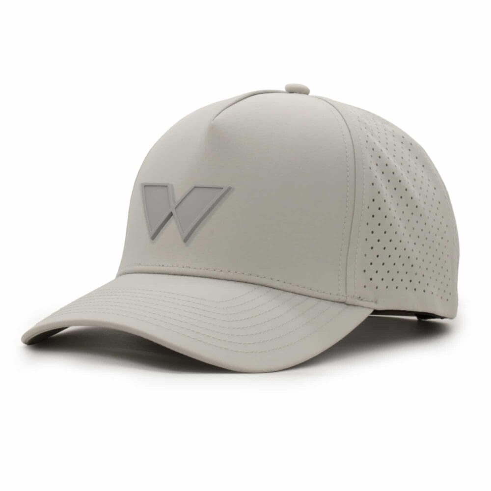 three-quarter view of a 5 panel, water resistant, floatable hat with a PVC patch. the patch is of the letter W from the brand name Wyldr. the hat is light tan. the patch matches the hat color.