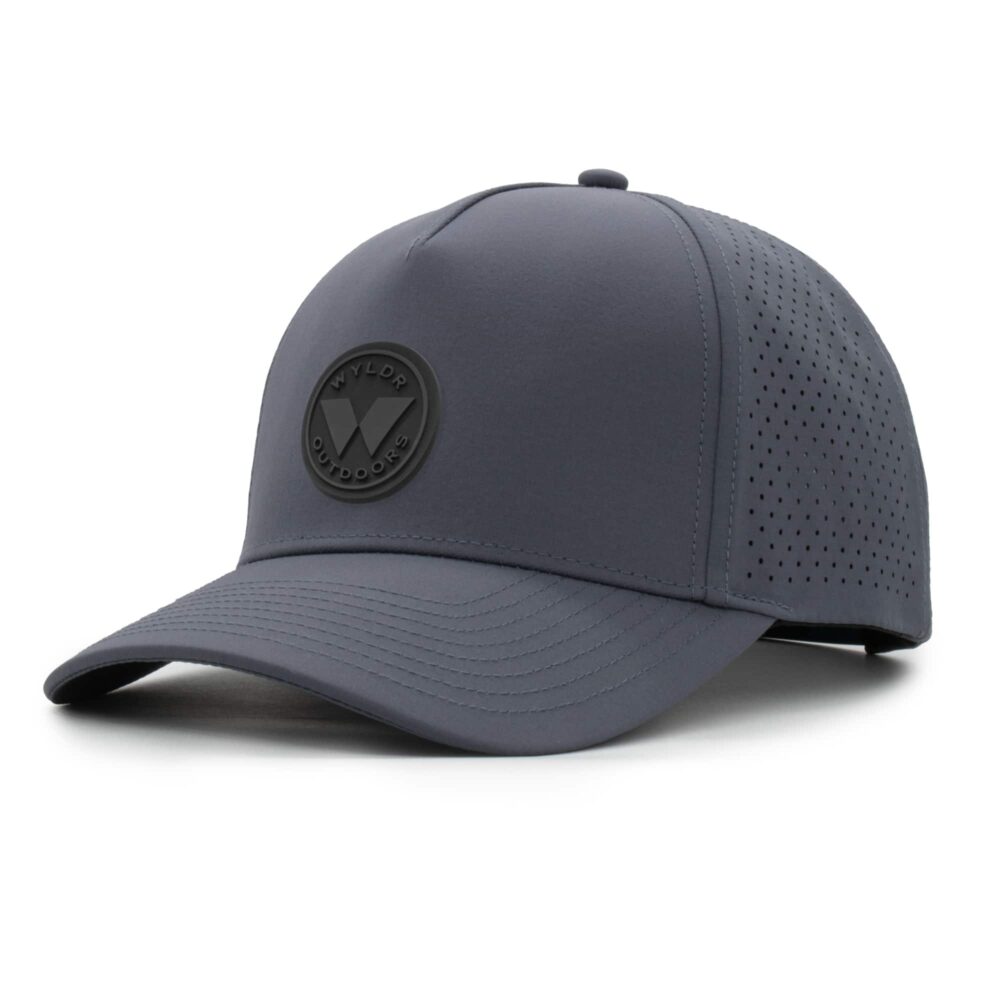 three-quarter view of a 5 panel, water resistant, floatable hat with a PVC patch. the patch is a round medallion featuring the letter W and the text Wyldr Outdoors. the hat is a dark blue-gray color
