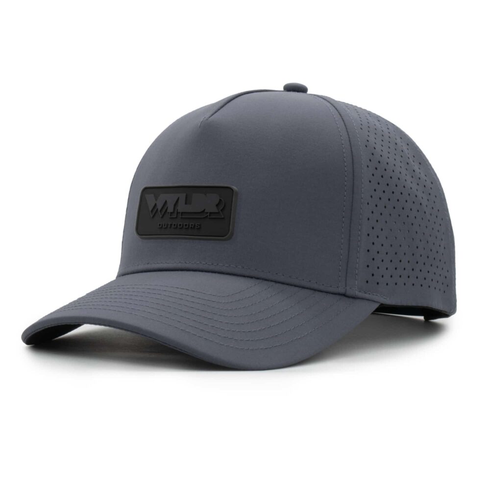 three-quarter view of a 5 panel, water resistant, floatable hat with a PVC patch. the patch is the brand name Wyldr contained in a rounded rectangle. the hat is a dark blue-gray color.